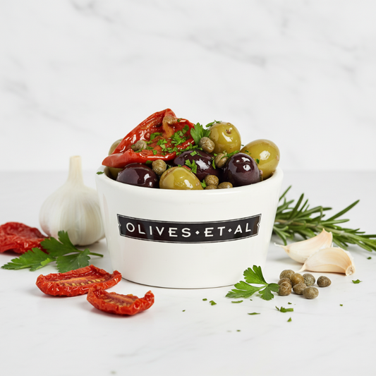 Assorted olives and vegetables in a container labeled 'Olives Et Al' on a white background.