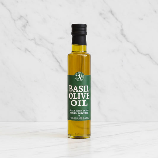 Bottle of basil olive oil on a white marble background