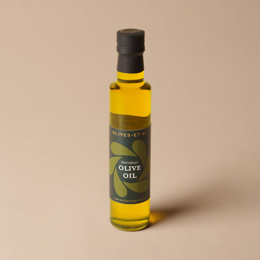 Olives Et Al Basil Olive Oil in a 250ml glass bottle, filled with golden extra virgin olive oil infused with fragrant basil. Made with 99% extra virgin olive oil, basil and basil aroma, this green-flecked oil adds fresh herbal flavour to festive cooking. Perfect for Christmas gifting, it brings a Mediterranean touch to seasonal salads, bruschetta, roast vegetables, pasta and warm bread. A thoughtful stocking filler or gourmet gift for food lovers who enjoy tasty oils, homemade meals and festive entertaining