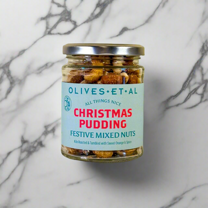 A jar of 'Olives & Al Christmas Pudding Festive Mixed Nuts' with a label indicating it is 'Pre-Order for Christmas'. The nuts are visible through the clear glass jar, showcasing their spiced and mixed appearance.