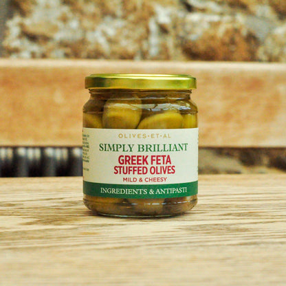 Jar of Greek Feta Stuffed Olives on a wooden surface with a blurred background