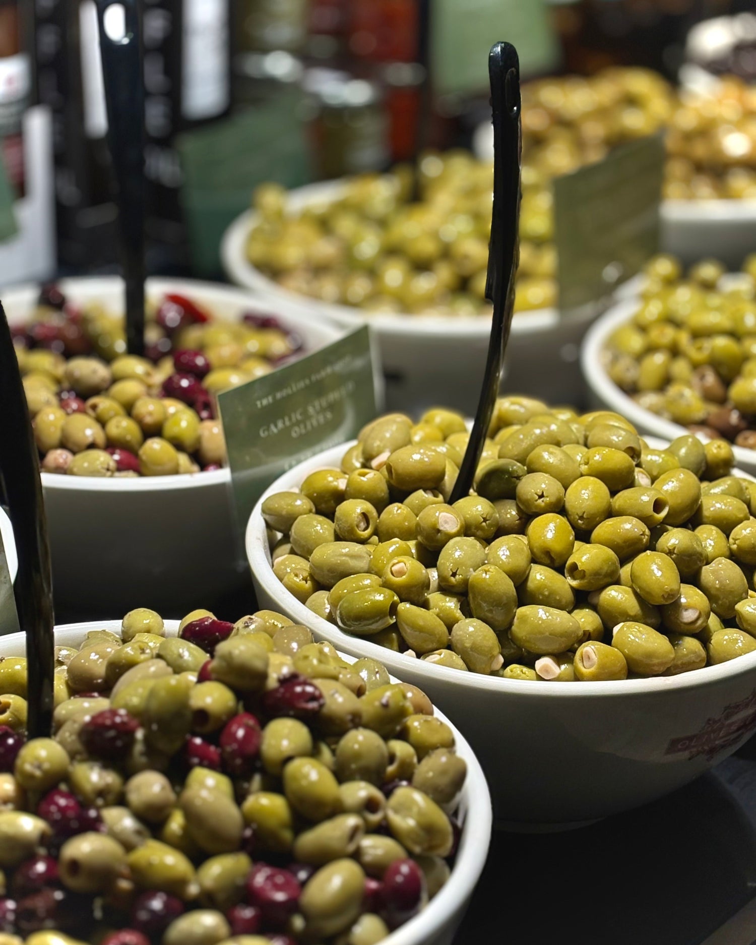 Bowls of green olives with a blurred background