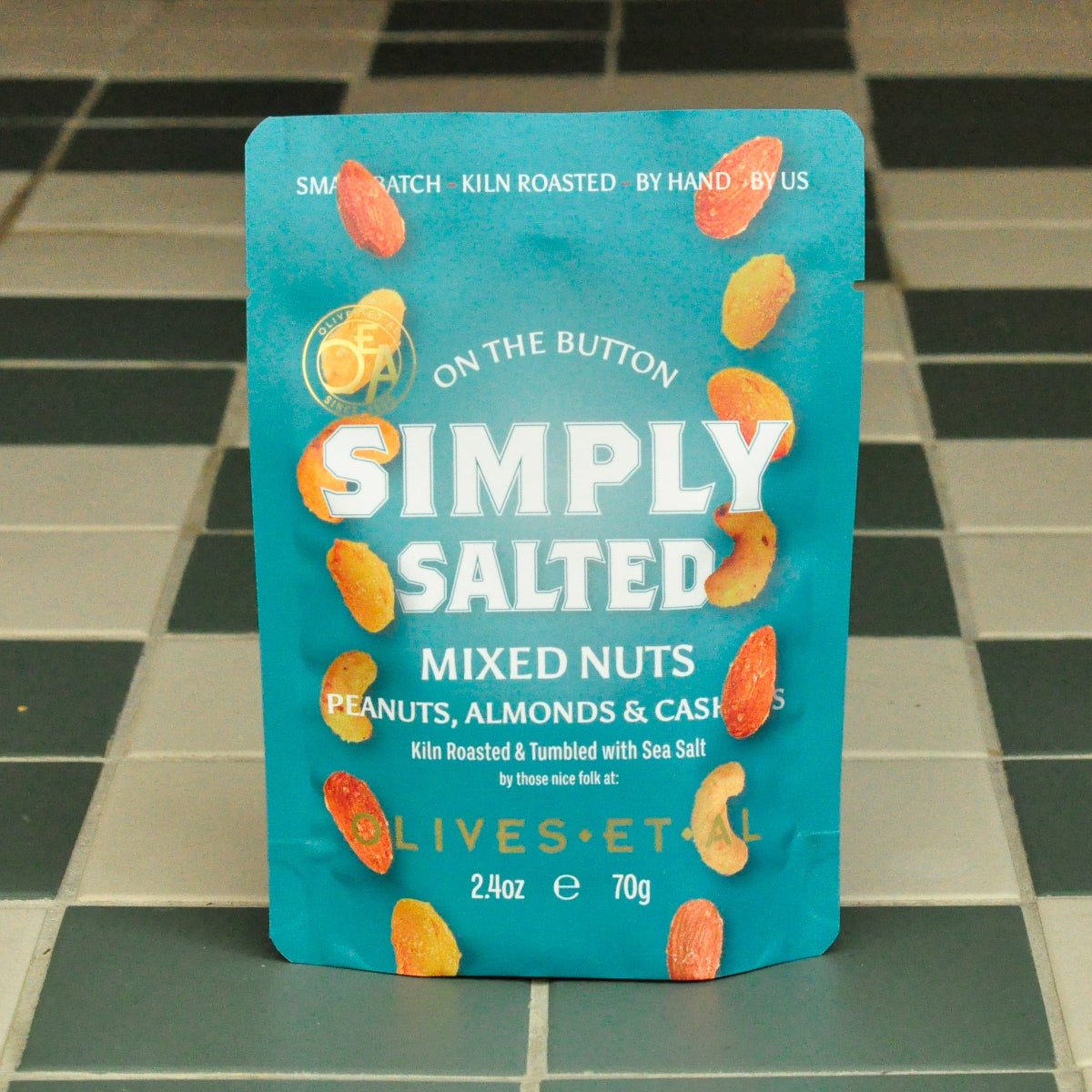 Teal package of 'Simply Salted' mixed nuts on a tiled floor