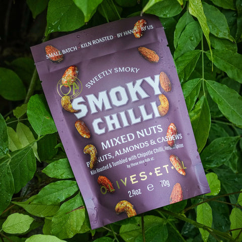 Purple package of Smoky Chilli mixed nuts on green leaves