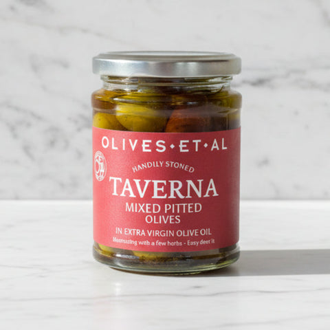 Jar of Taverna mixed pitted olives on a wooden surface