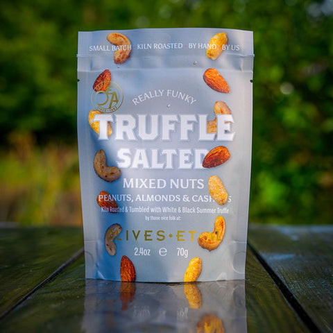 Packaged mixed nuts with truffle flavor on a wooden surface