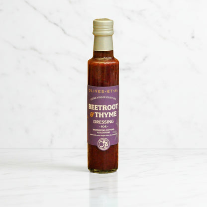 Bottle of beetroot and thyme dressing on a white background