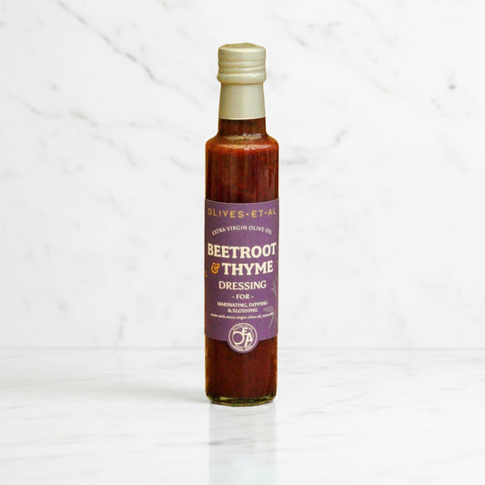 Bottle of beetroot and thyme dressing on a white background