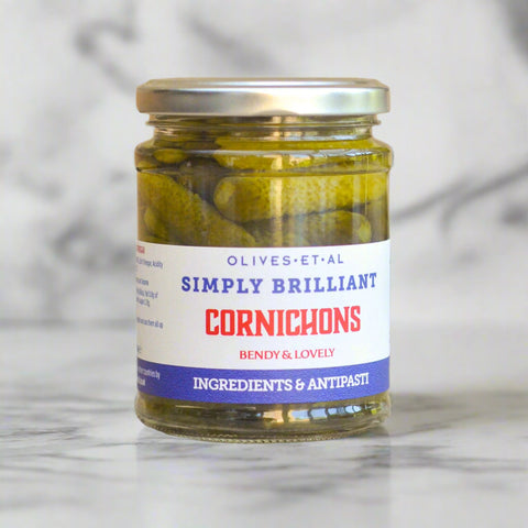 a jar of  cornichons on a marble background