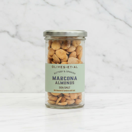 Jar of Olives Et Al Marcona Almonds with a label on a marble background
