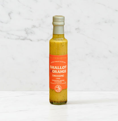 Bottle of 'Shallot & Orange' dressing on a marble background