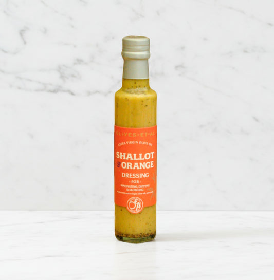 Bottle of 'Shallot & Orange' dressing on a marble background