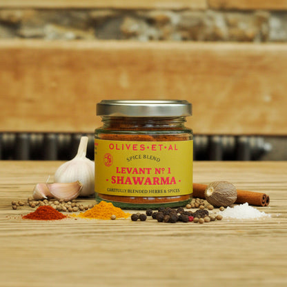 Jar of Olives et al Levant No 1 Shawarma spice blend on a wooden surface with spices around.